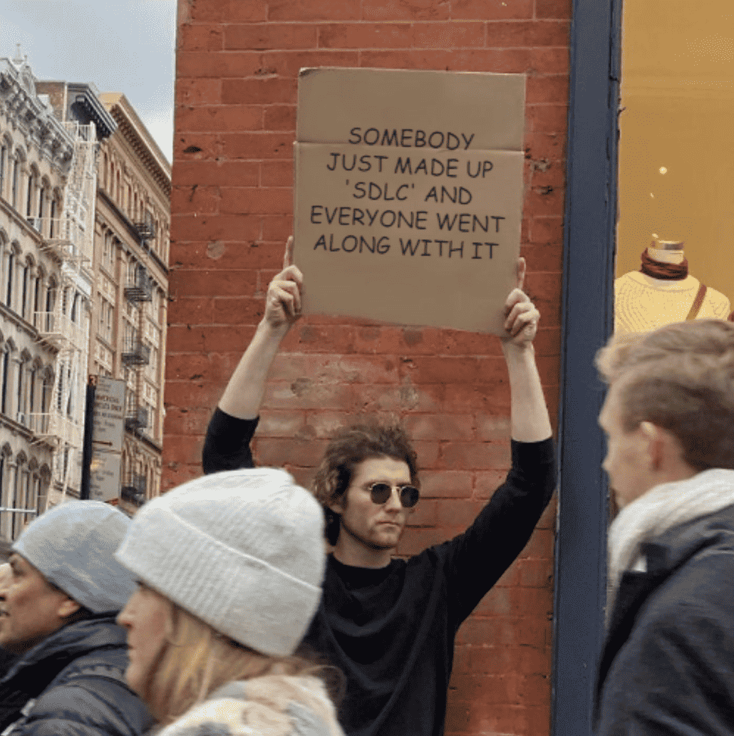Man protesting with sign: Somebody just made up SDLC and everyone went along with it.